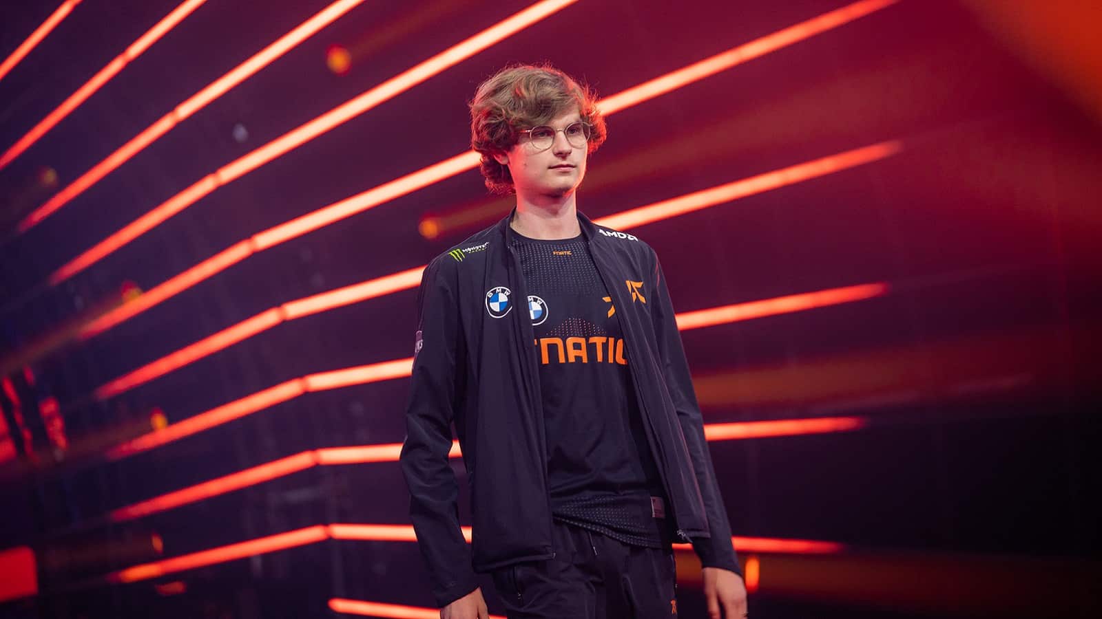 Pro LoL player Elias “Upset” Lipp walks out from a red-lit tunnel in his Fnatic attire.
