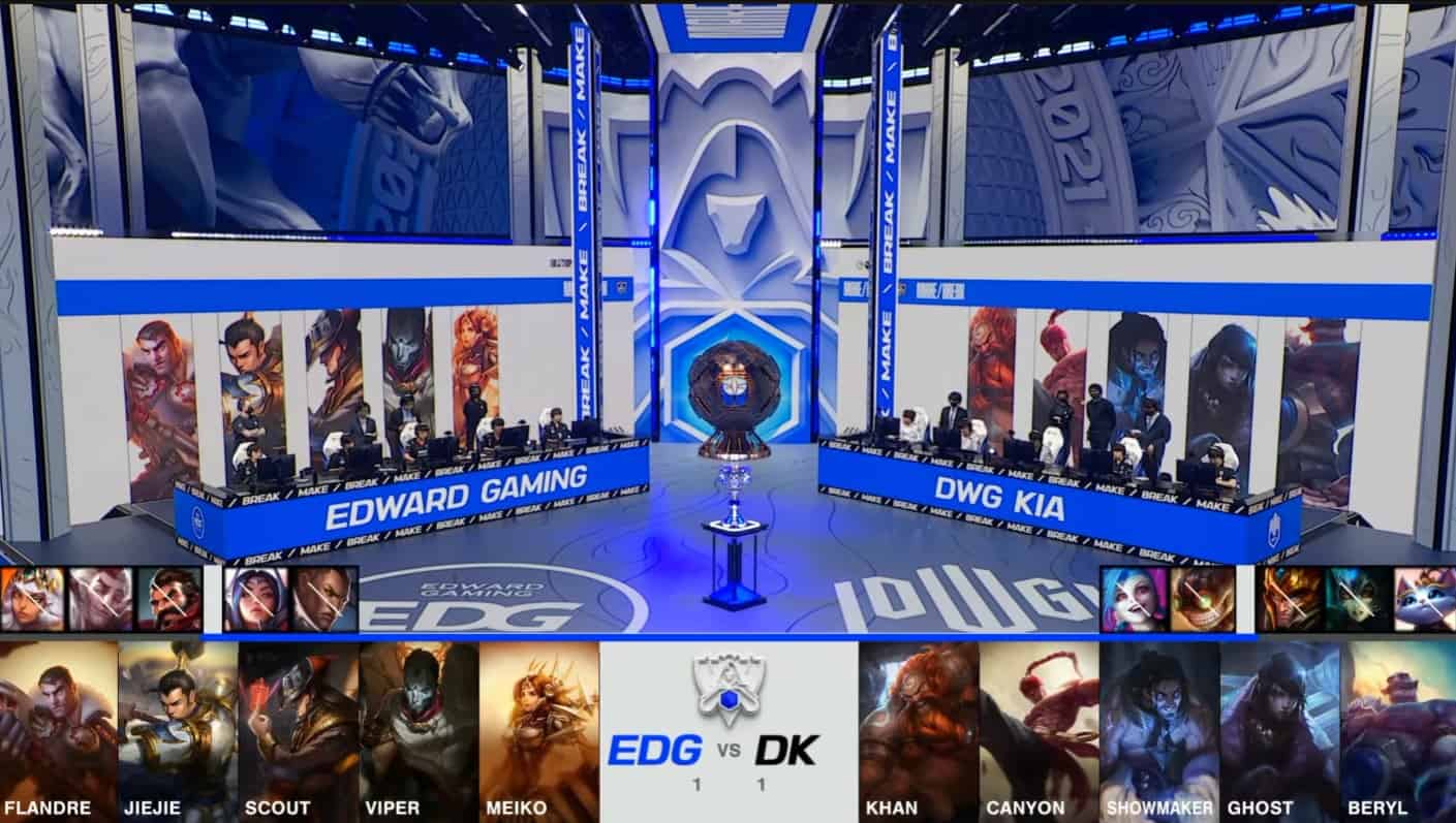 A screenshot from the 2021 LoL World Championship Grand Finals broadcast, showing the Game Three champion drafts between DAMWON KIA and Edward Gaming with a shot of both teams and the Summoner's Cup on the Worlds 2021 stage above.