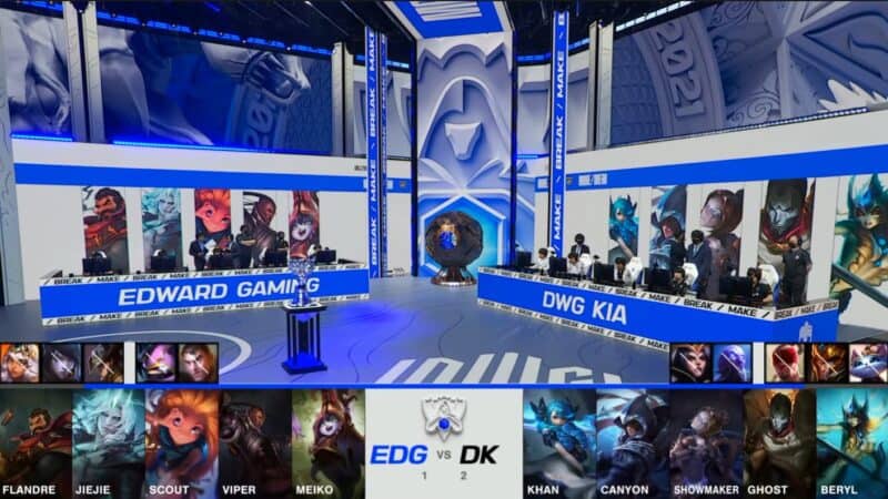 A screenshot from the 2021 LoL World Championship Grand Finals broadcast, showing the Game Four champion drafts between DAMWON KIA and Edward Gaming with a shot of both teams and the Summoner's Cup on the Worlds 2021 stage above.