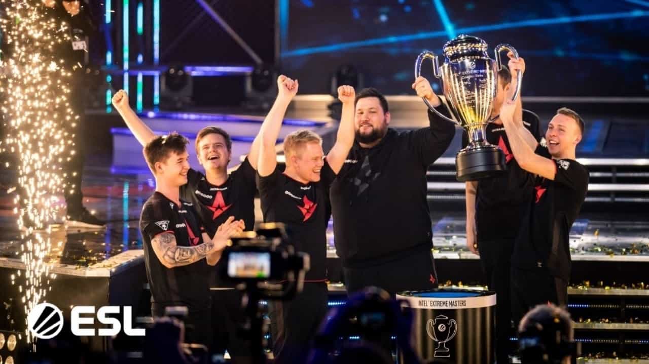 The Astralis CS:GO squad celebrates a victory and hoists on a trophy on stage.
