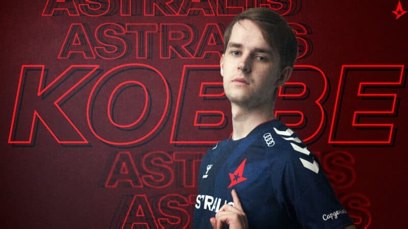 Pro LoL player Kasper "Kobbe" Kobberup points to his Astralis jersey with his name Kobbe behind him on a red background. LEC Astralis Summer Preview
