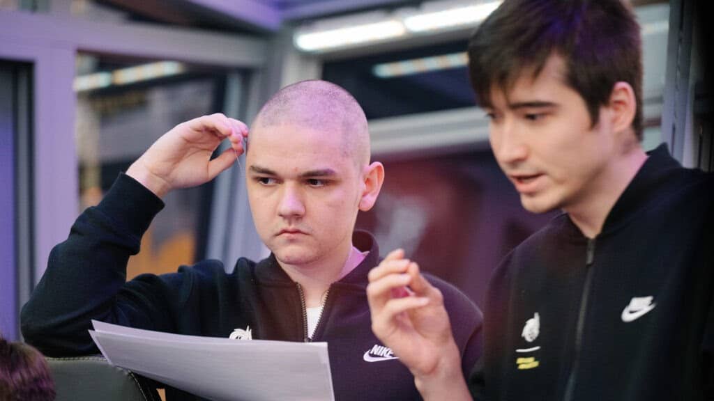 Yatoro holds a page of notes as he shares a conversation with his team during the WePlay AniMajor