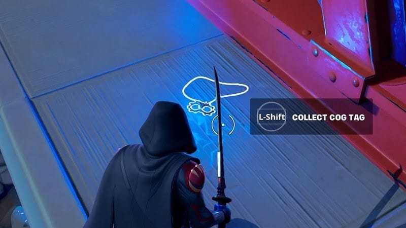 A player walks up to a cog tag lying at one of the POIs to collect it