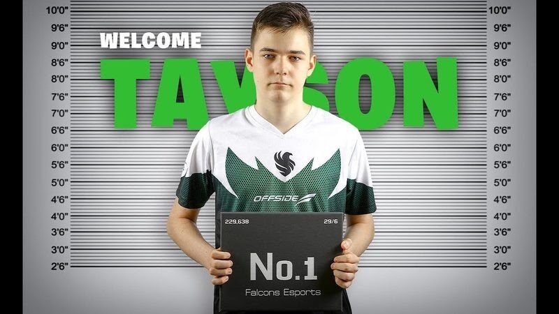 Slovenian player TaySon stands in his Falcons Esports jersey infront of a police line up holding a board which says "No. 1"